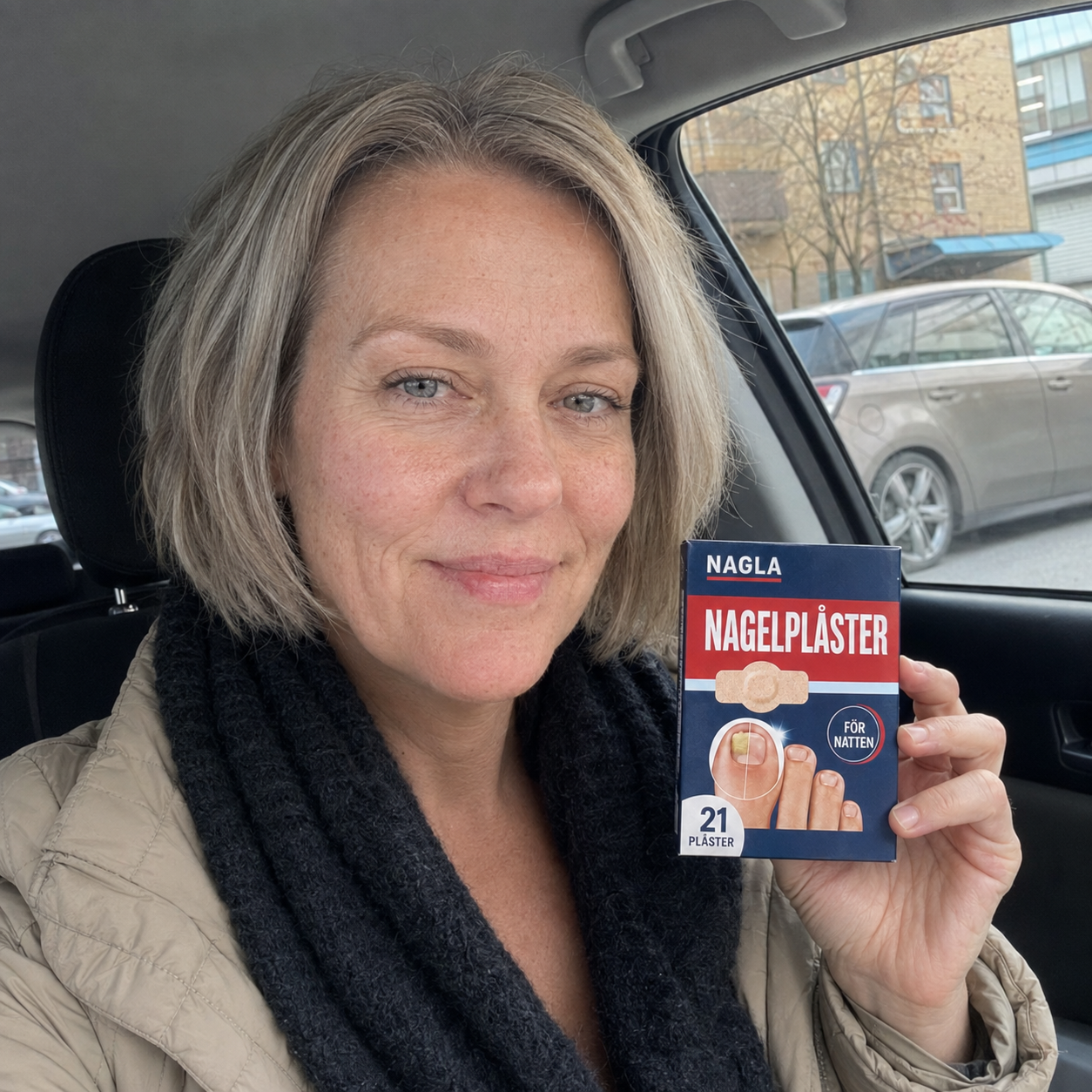 Lena, 55 år håller upp en förpackning NAGLA Nagelplåster